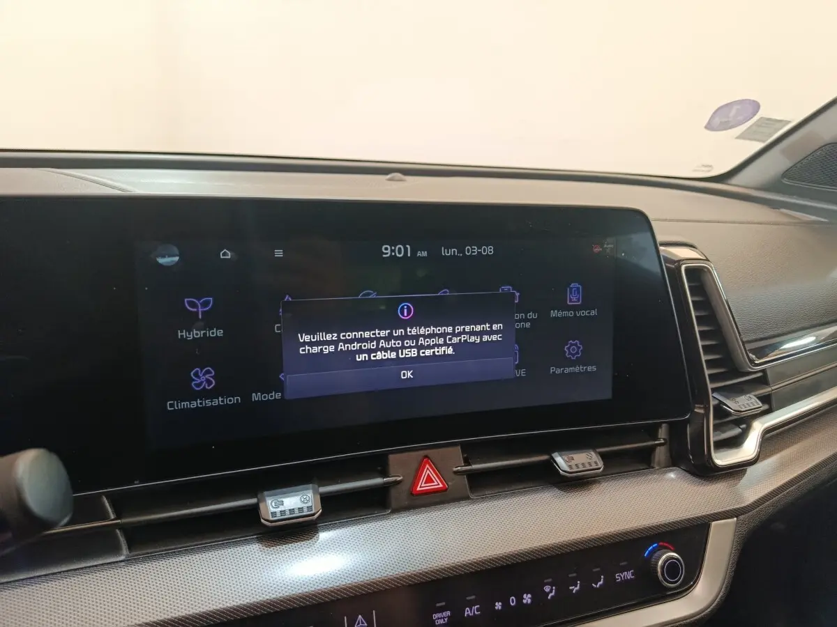 Vue rapprochée de l’écran tactile central du tableau de bord du Kia Sportage gris clair avec message de connexion Android Auto/Apple CarPlay.