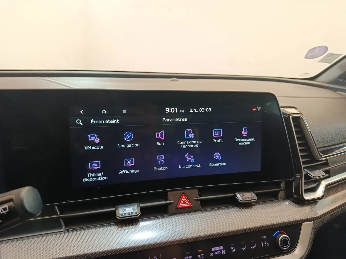 Vue intérieure du tableau de bord du KIA Sportage gris clair 2022 avec écran tactile multifonctions allumé.