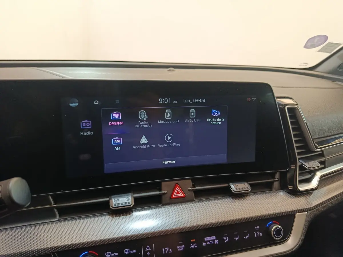 Vue intérieure du tableau de bord du Kia Sportage gris clair 2022, écran tactile multimédia allumé.