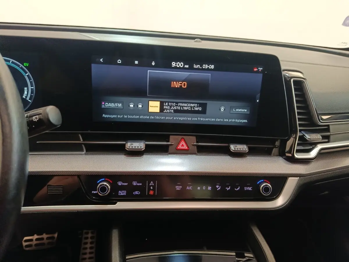 Tableau de bord du Kia Sportage gris clair 2022, vue frontale sur écran tactile 12,3 pouces et commandes climatisation digitales.