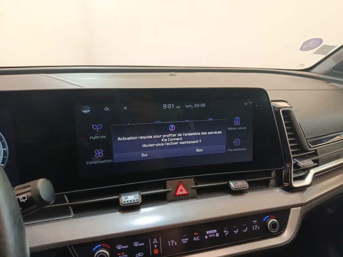 Vue intérieure du tableau de bord du Kia Sportage gris clair 2022, avec écran tactile central allumé.