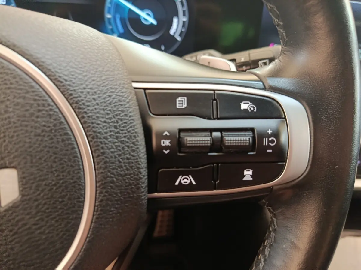 Gros plan sur les commandes multifonctions à droite du volant cuir noir du Kia Sportage gris clair 2022.
