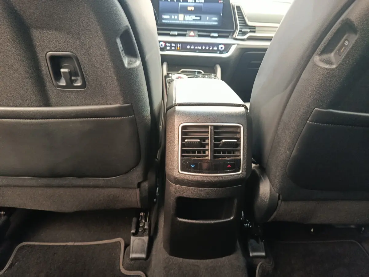 Vue arrière de l’habitacle du Kia Sportage gris clair 2022, avec ventilation et commandes climatisation arrière visibles.