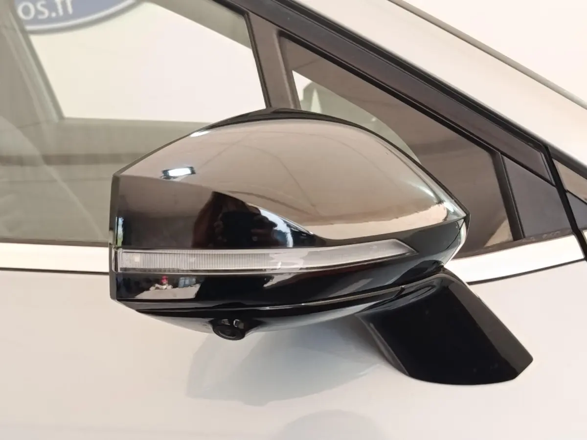 Gros plan sur le rétroviseur droit noir brillant avec clignotant intégré du KIA Sportage gris clair 2022.
