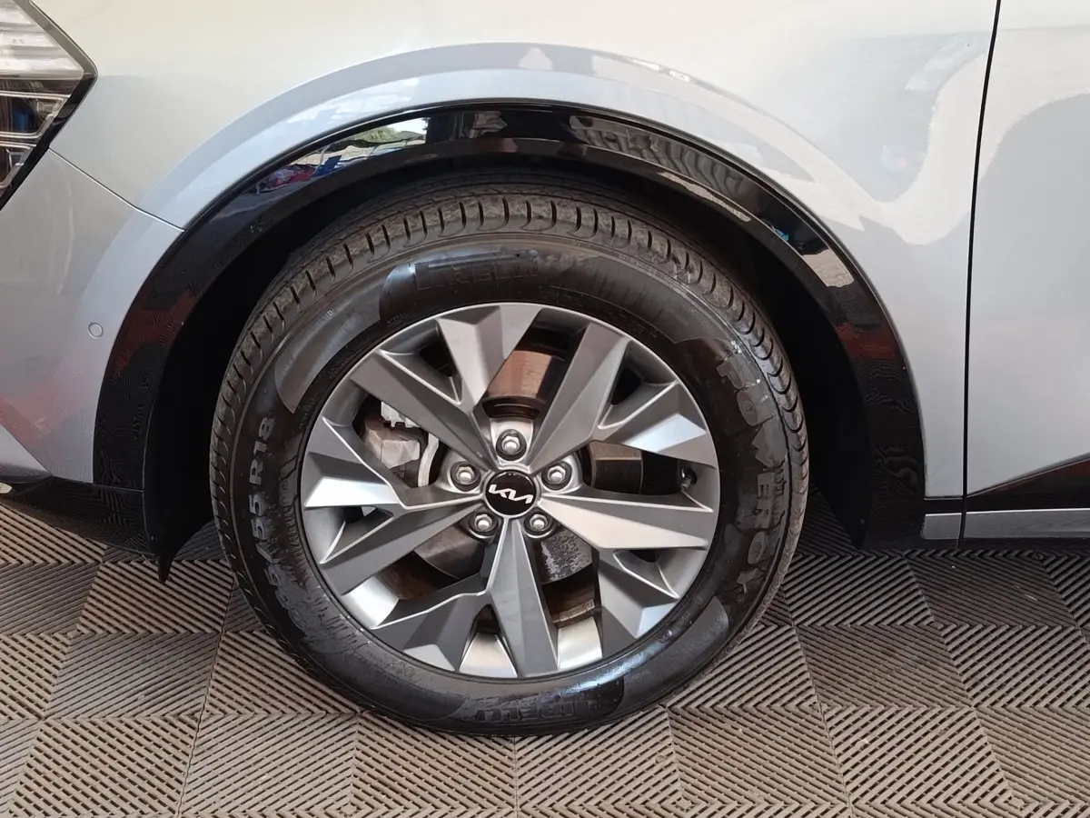 Gros plan sur la roue avant droite gris clair du Kia Sportage 2022 avec jante alliage et logo Kia au centre.