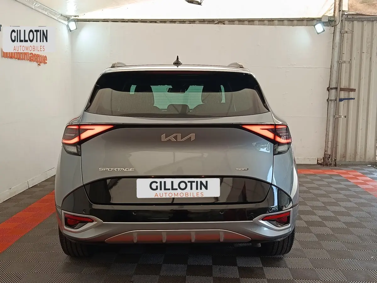 Vue arrière d'un KIA Sportage gris clair 2022 avec feux LED allumés et logo GT-LINE PREMIUM visible.