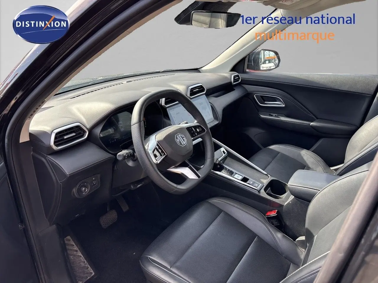 Vue intérieure côté conducteur du MG ZS 1.5L Hybrid+ 2025 en Pebble Black, avec tableau de bord et sièges cuir noirs.