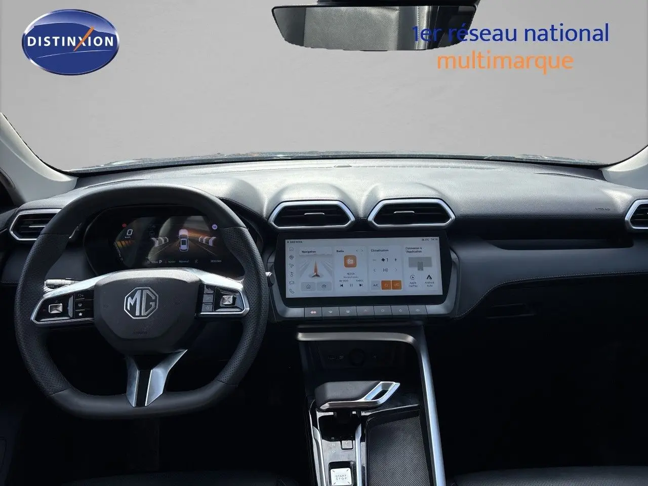 Vue intérieure frontale du tableau de bord noir du MG MOTOR ZS 1.5L HYBRID+ 197CH LUXURY avec écran tactile et volant multifonction.