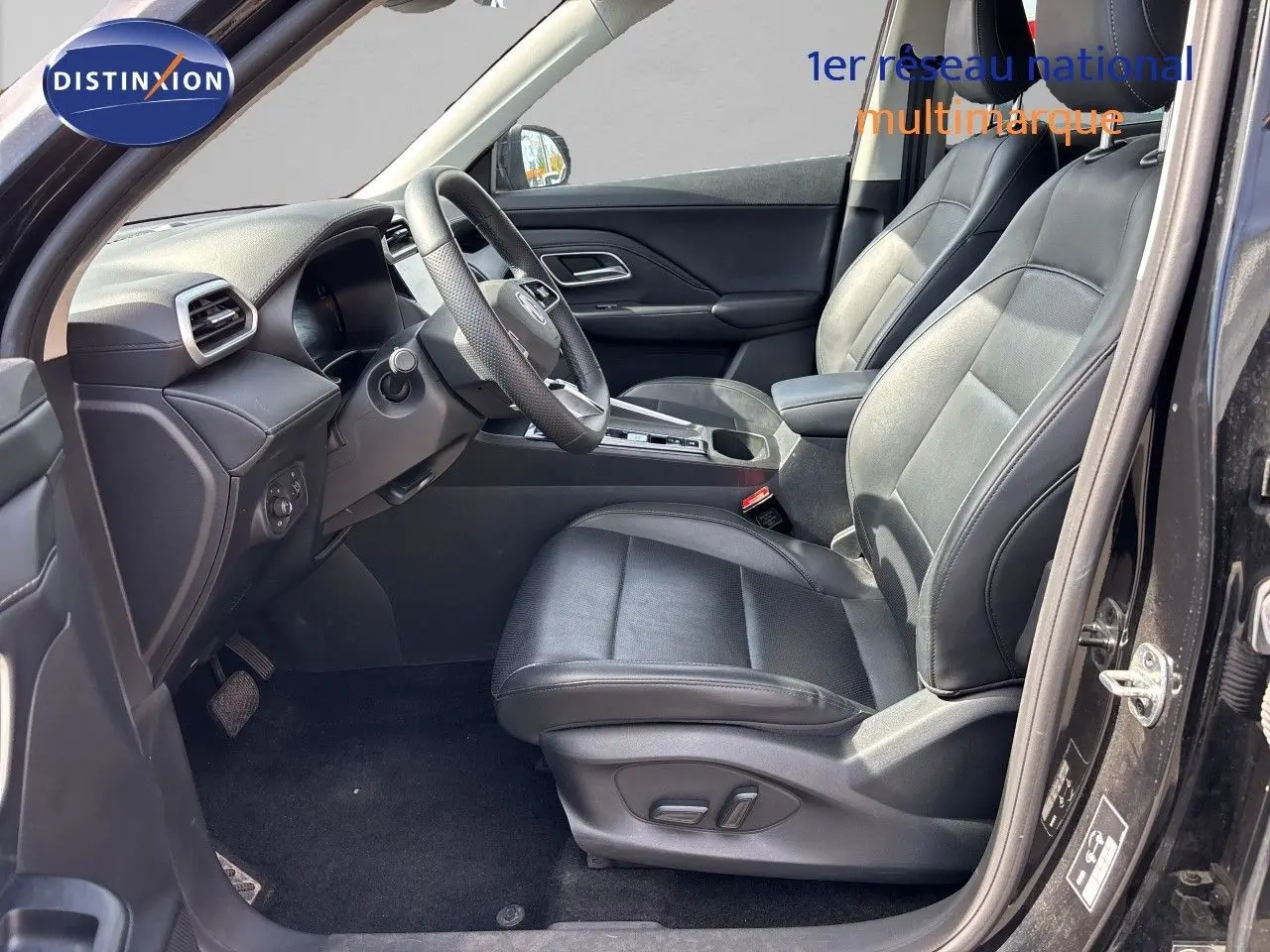 Vue intérieure côté conducteur du MG ZS 2025 noir Pebble Black, sièges cuir noirs et tableau de bord moderne.