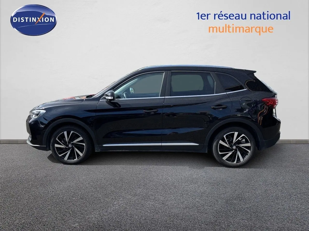 Vue de profil côté gauche du MG ZS 1.5L Hybrid+ 197ch Luxury noir Pebble Black Metal avec jantes alliage bicolores.