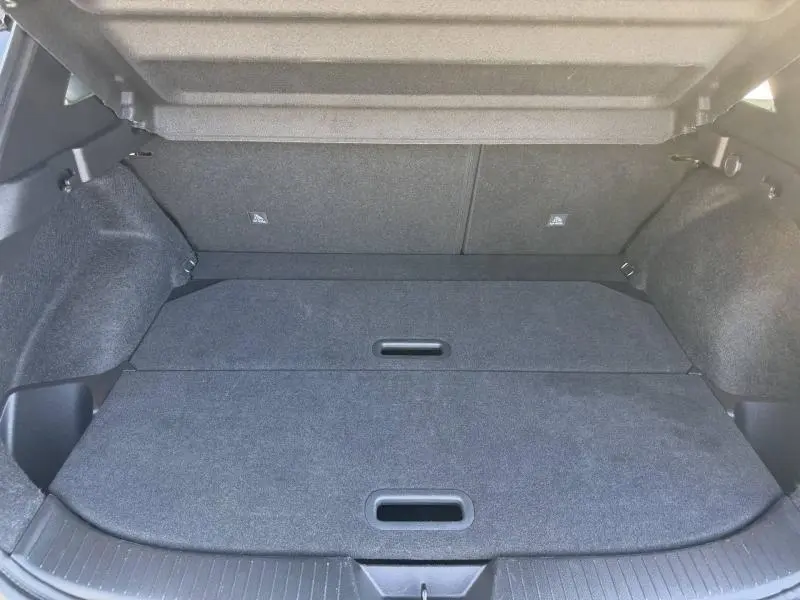 Vue intérieure du coffre spacieux et plat du Nissan Qashqai 2025 noir Kuro Métallisé, avec plancher modulable fermé.
