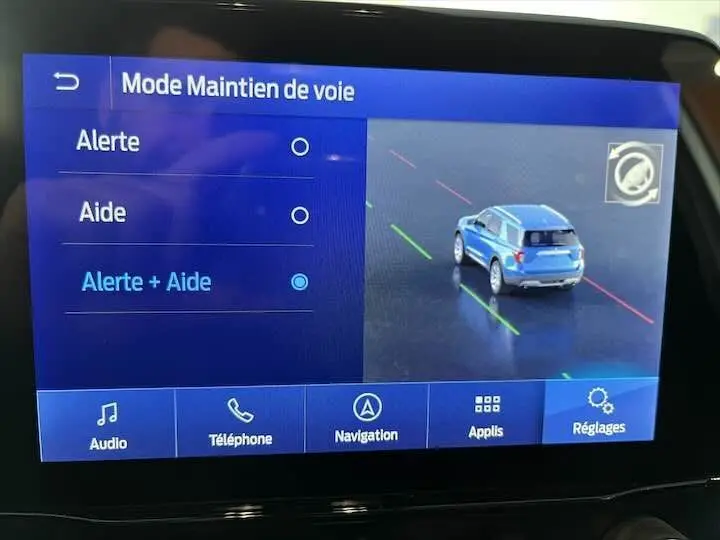 Écran tactile du système multimédia montrant le mode maintien de voie avec un véhicule bleu vu de l'arrière en simulation.
