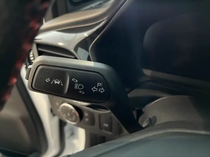 Gros plan sur la commande des clignotants et aides à la conduite dans le Ford Puma blanc glacier 2022 côté gauche.