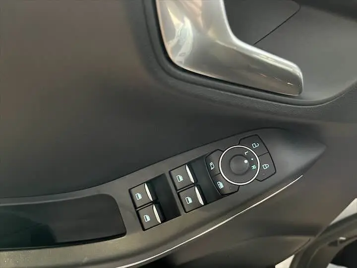 Commande des vitres et rétroviseurs côté conducteur dans l'intérieur noir du Ford Puma blanc glacier 2022.