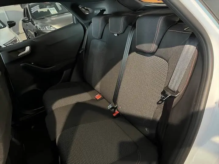 Vue intérieure arrière droite des sièges noirs avec surpiqûres rouges du Ford Puma blanc Glacier 2022 finition ST-Line.
