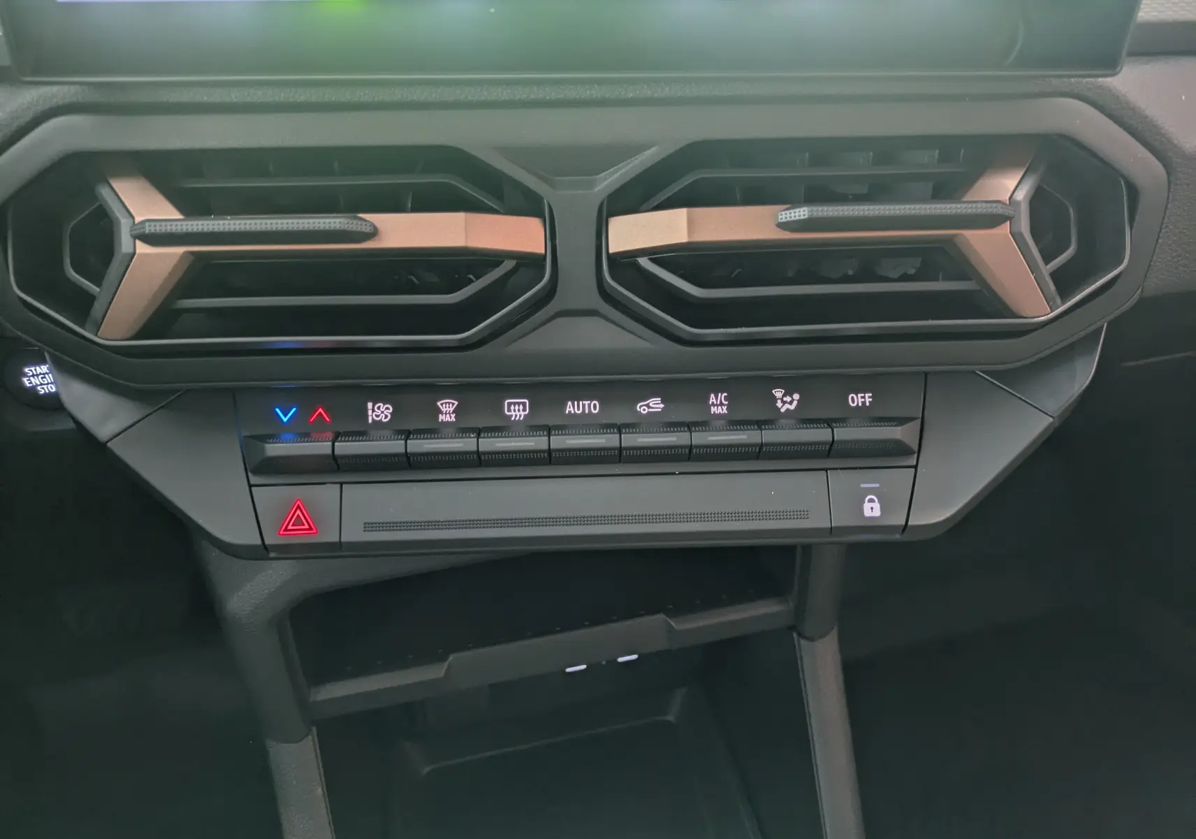 Vue rapprochée de la console centrale du Dacia Duster 1.6 Hybrid 140 Extreme avec aérateurs hexagonaux et commandes climatisation.