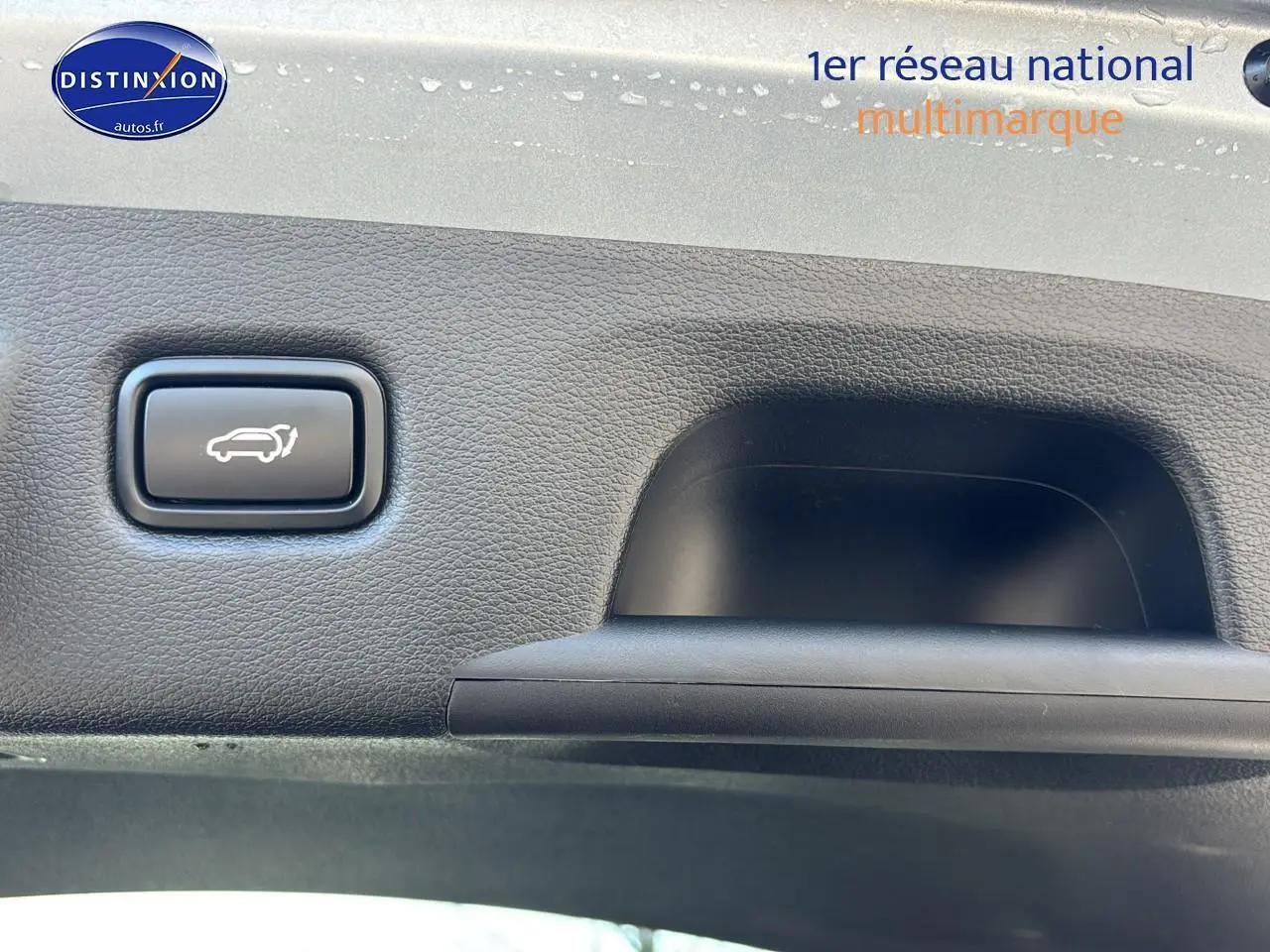 Bouton d'ouverture électrique du coffre sur la garniture intérieure d'un KIA Xceed gris 2024.