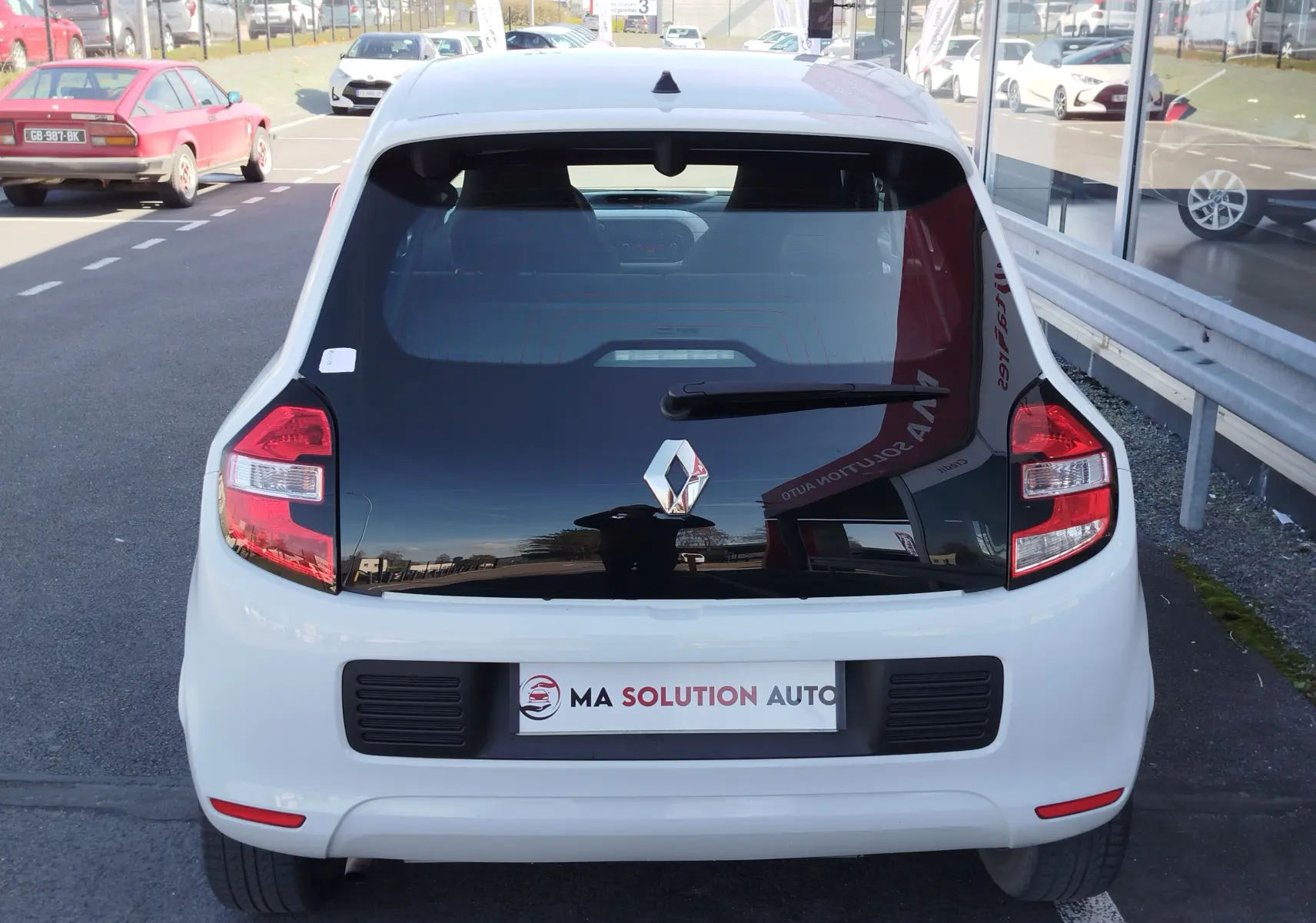 Vue arrière d'une Renault Twingo blanche Cristal de 2016 avec lunette arrière noire et logo Renault centré.