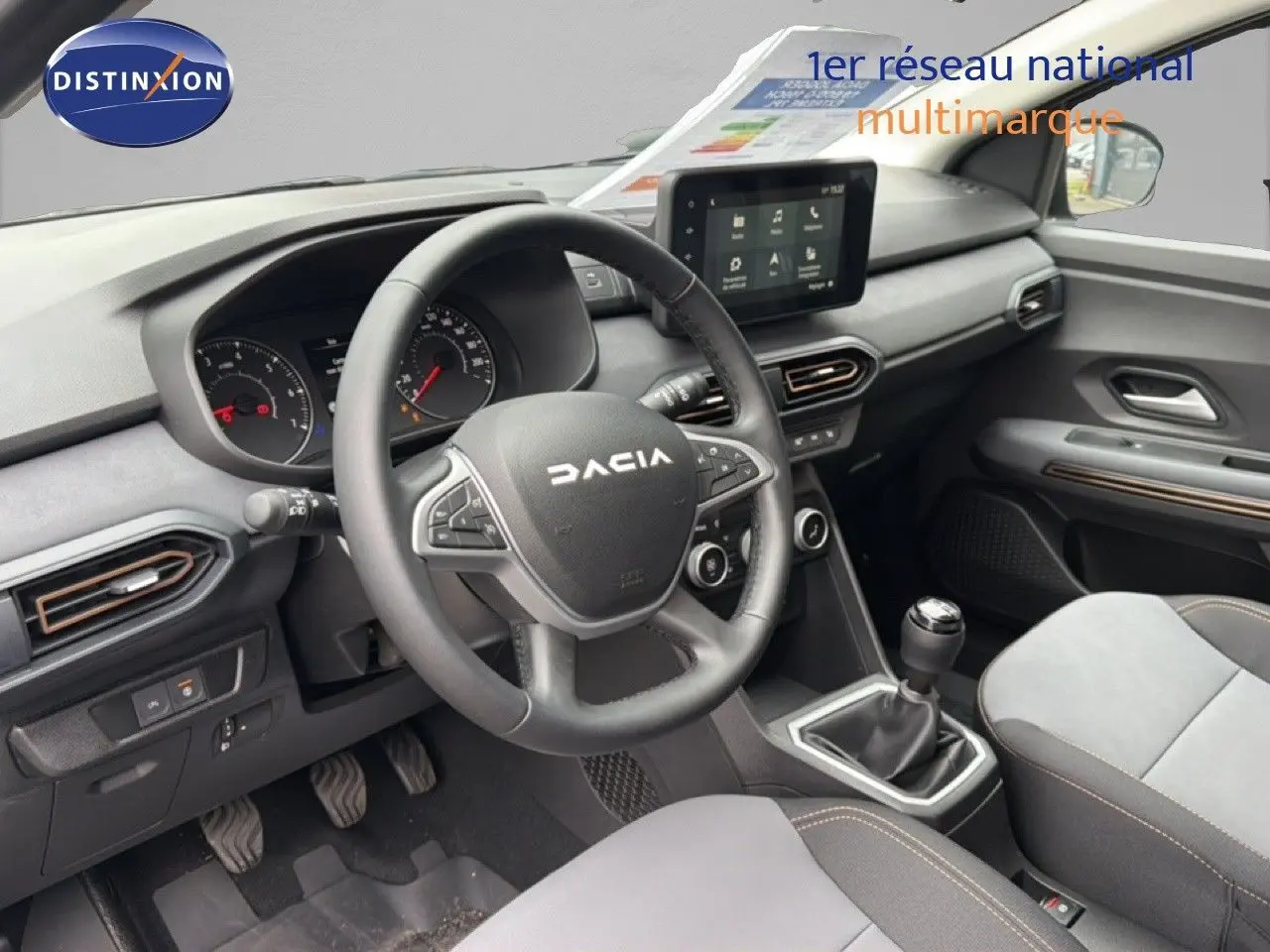 Vue intérieure avant du tableau de bord et volant noir de la Dacia Jogger 2026, avec boîte manuelle et écran tactile central.