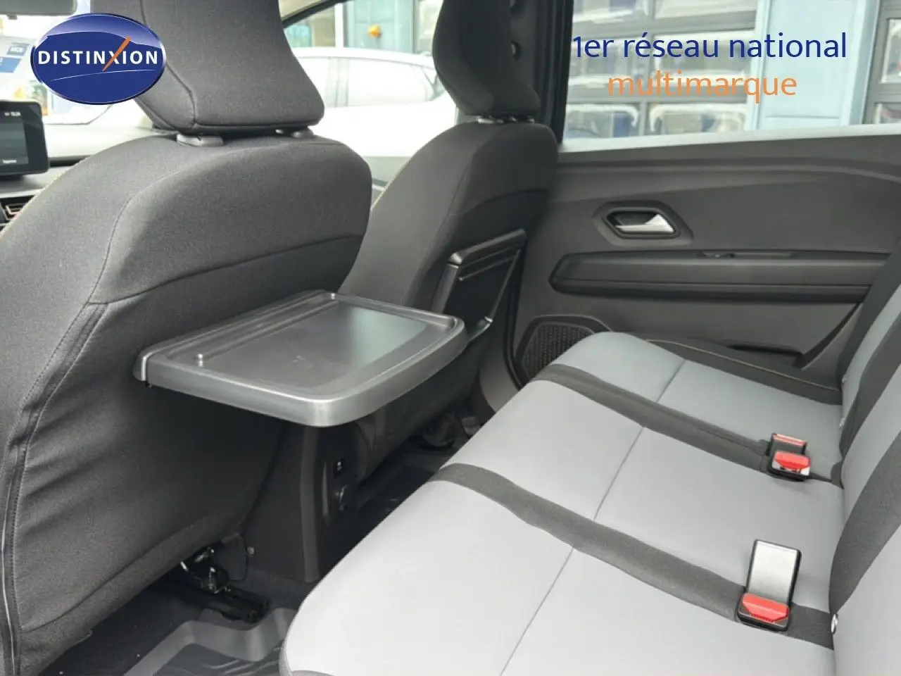 Vue intérieure côté droit des sièges arrière gris clair avec tablette rabattable sur un Dacia Jogger vert cèdre métal 2026.