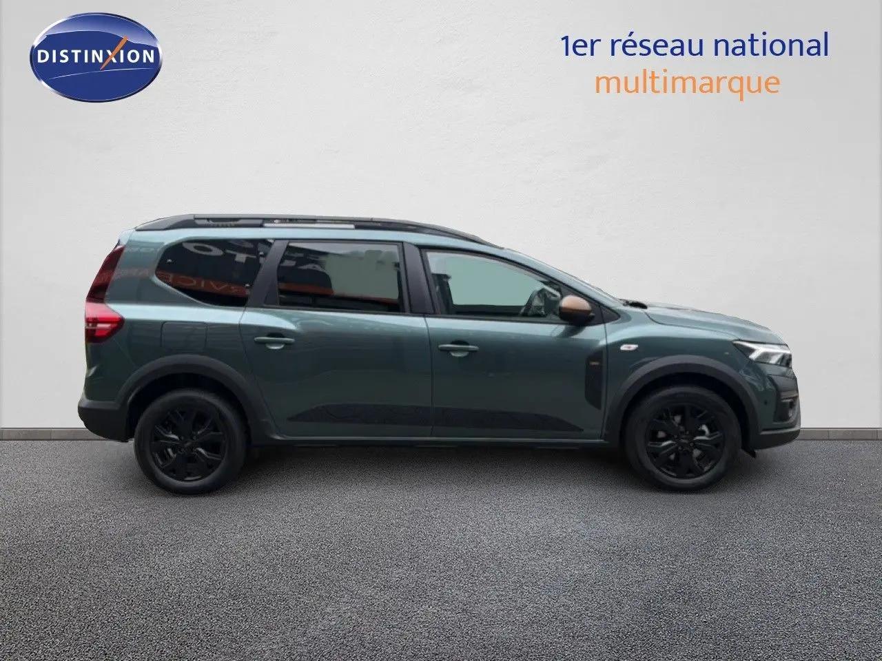 Vue latérale droite d'un Dacia Jogger 2026 vert cèdre métallisé avec jantes noires et toit ouvrant.