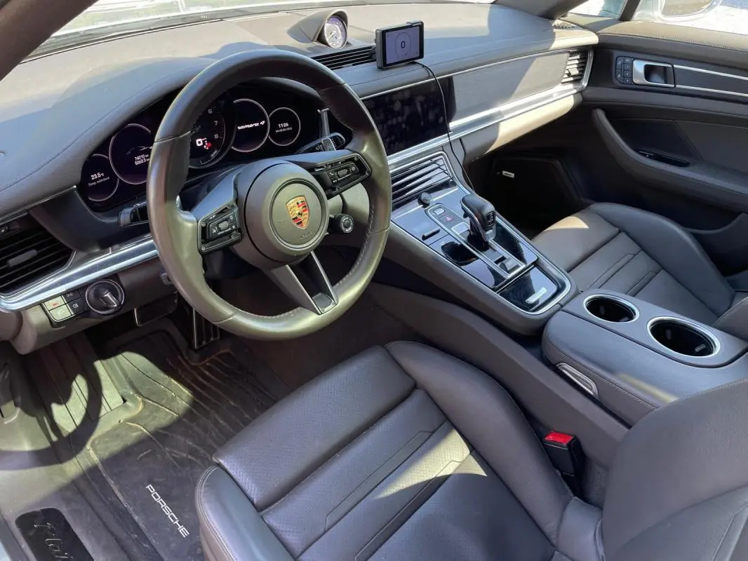 Vue intérieure côté conducteur de la Porsche Panamera 4 V6 Hybrid 2022, avec tableau de bord gris et console centrale moderne.