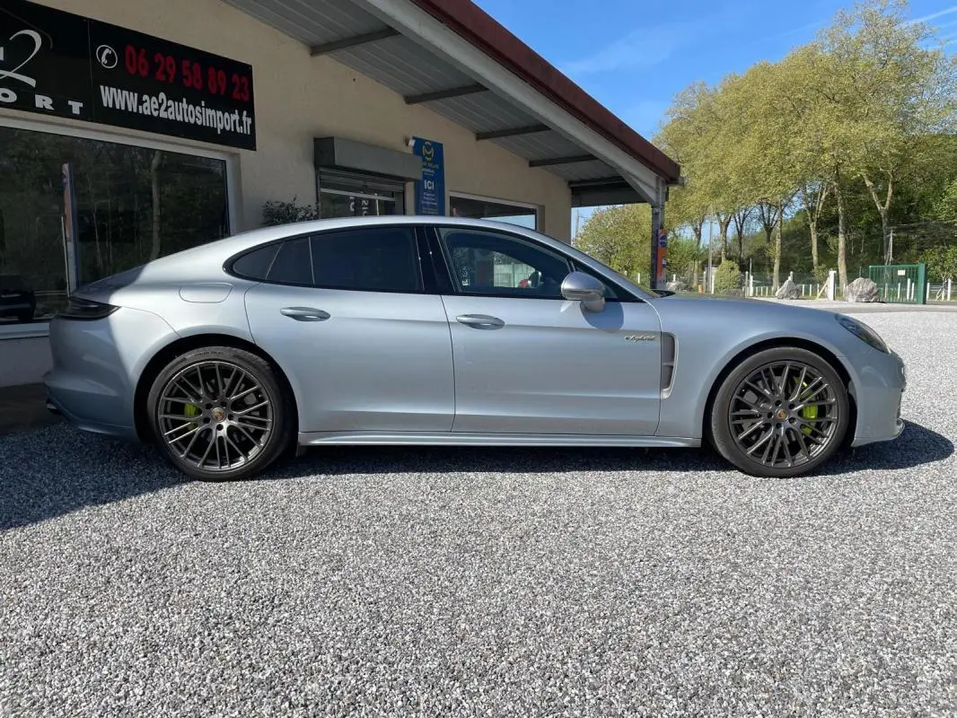 Vue de profil côté gauche d'une Porsche Panamera 4 V6 3.0 Hybrid gris métallisé avec jantes noires et étriers verts.