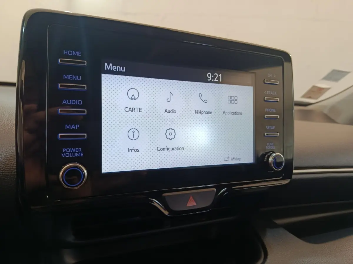 Écran tactile central de la Toyota Yaris hybride 2022, affichant le menu principal avec commandes latérales.