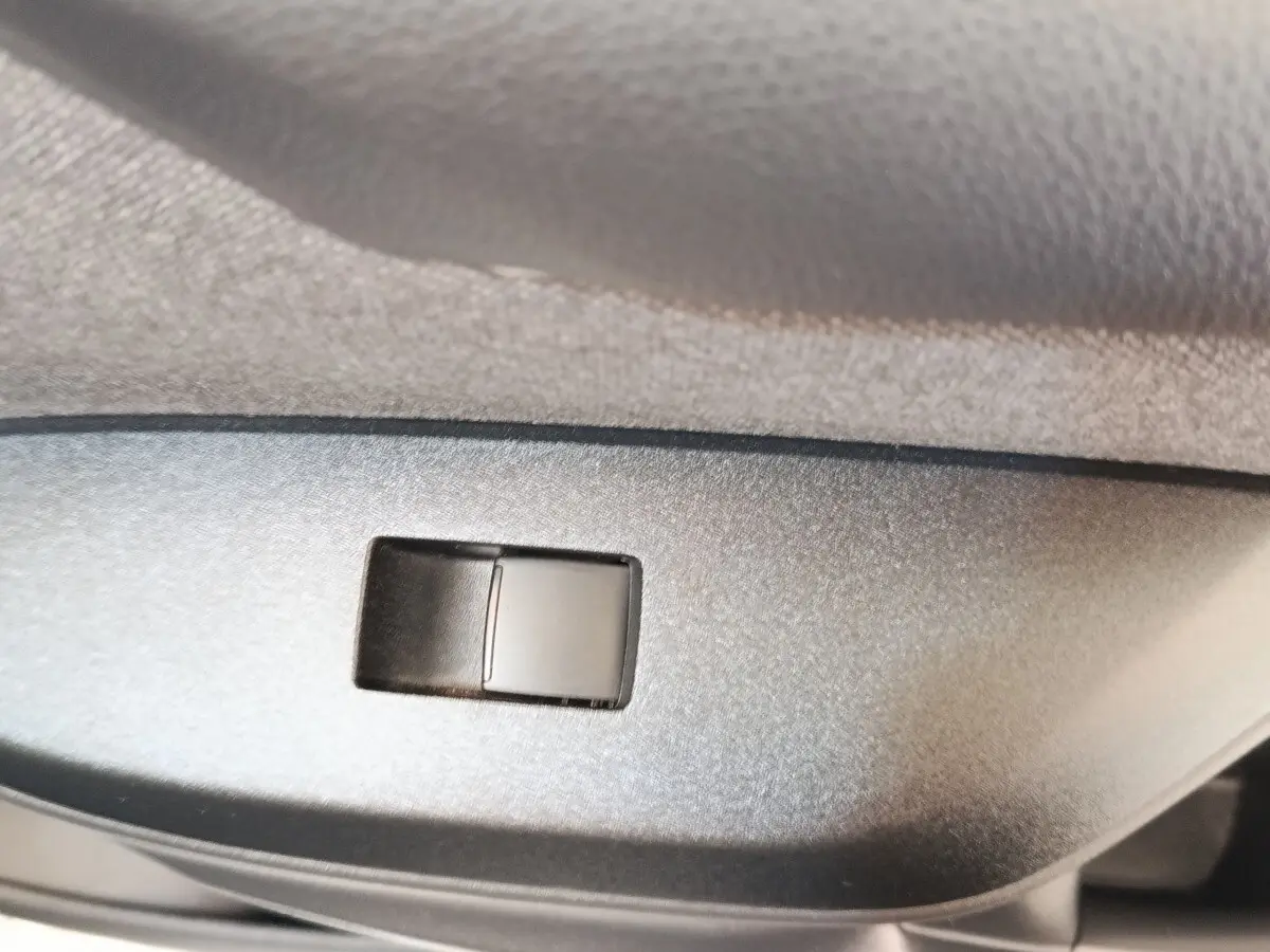 Gros plan sur le bouton de réglage du siège côté conducteur dans l’habitacle de la Toyota Yaris blanche hybride 2022.
