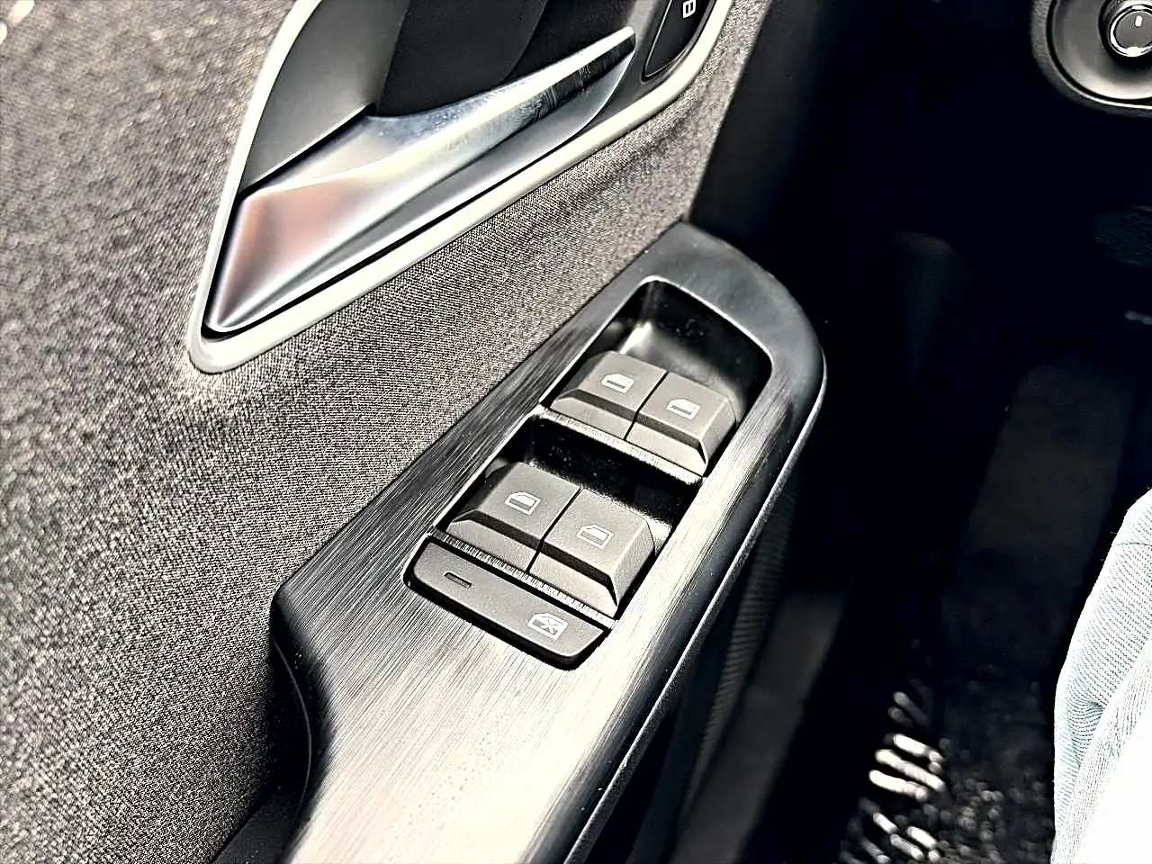 Gros plan sur les commandes des vitres électriques côté gauche de la porte avant d'un MG ZS 1.5 hybrid Camden grey.