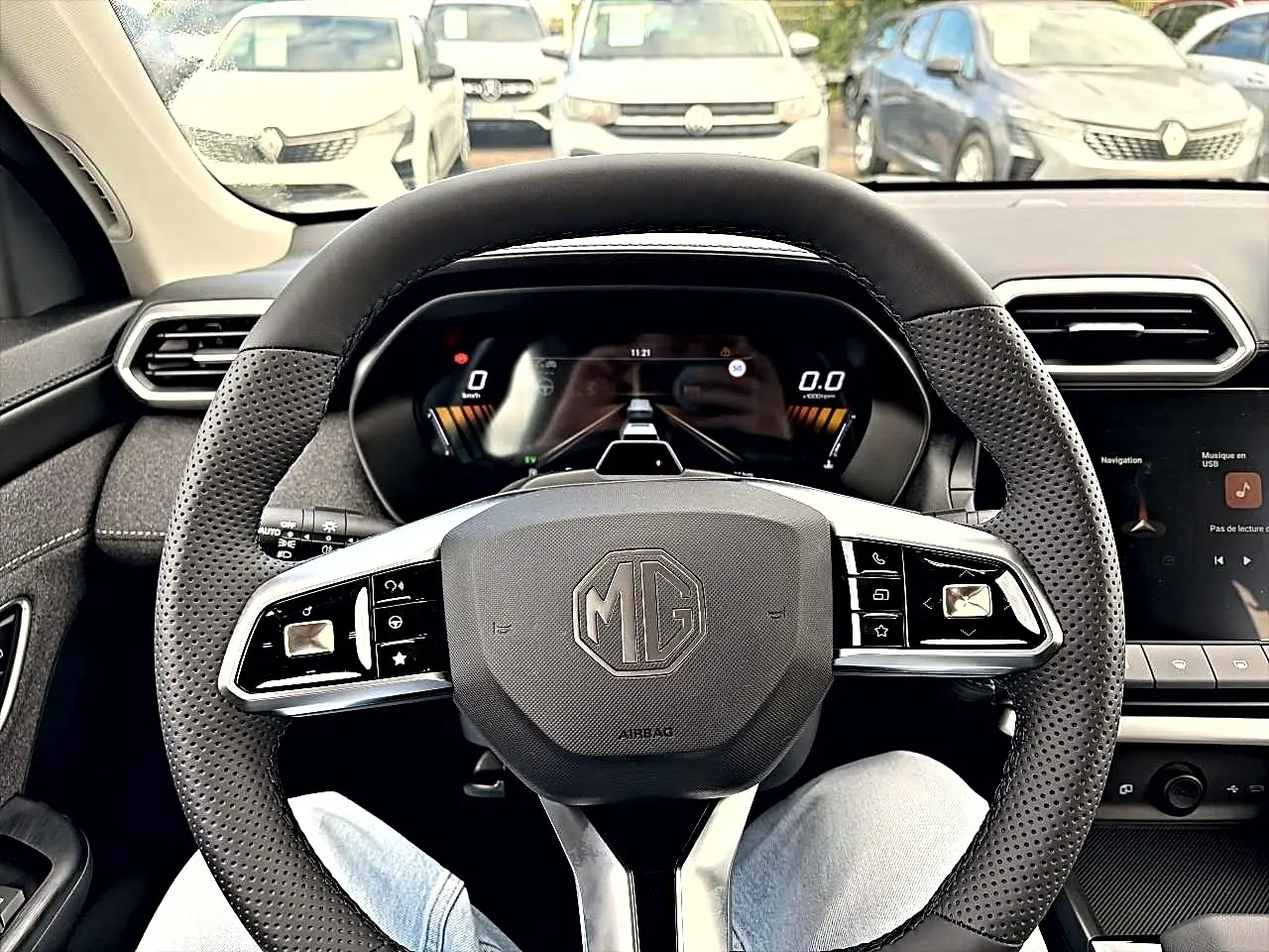 Vue intérieure centrée sur le volant multifonction noir du MG Motor ZS 1.5 hybrid 197, avec tableau de bord digital.