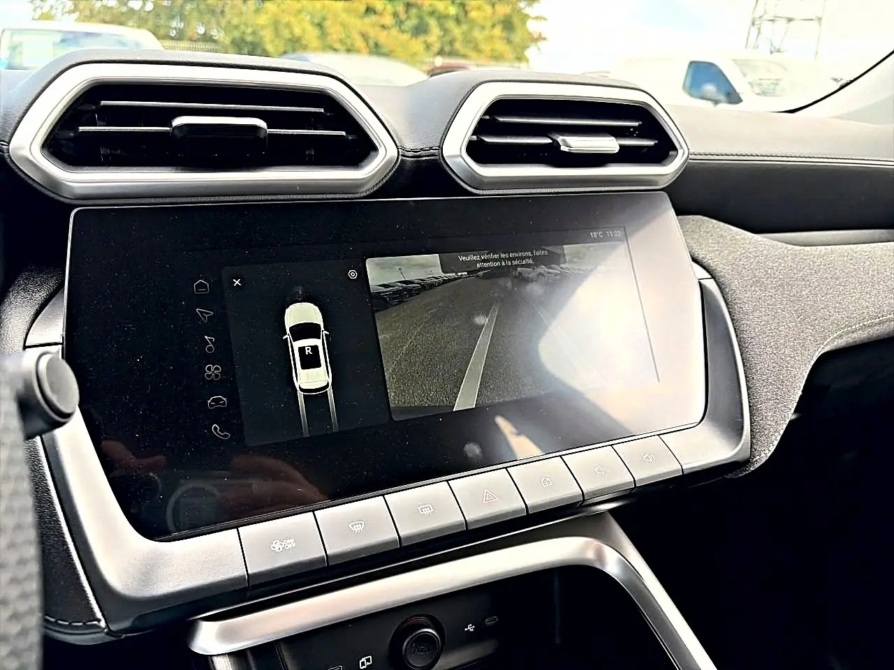 Vue rapprochée de l’écran tactile central et des aérateurs hexagonaux du tableau de bord intérieur du MG Motor ZS Camden grey.