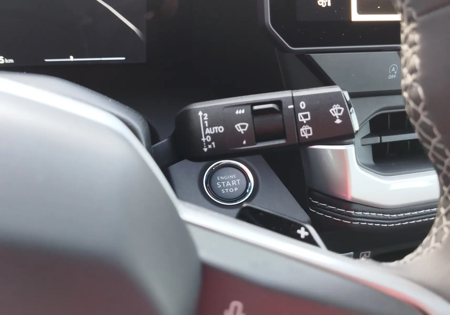 Détail intérieur du Jeep Compass 2026 noir Vulcano, montrant la commande des essuie-glaces et le bouton start/stop sur tableau de bord.
