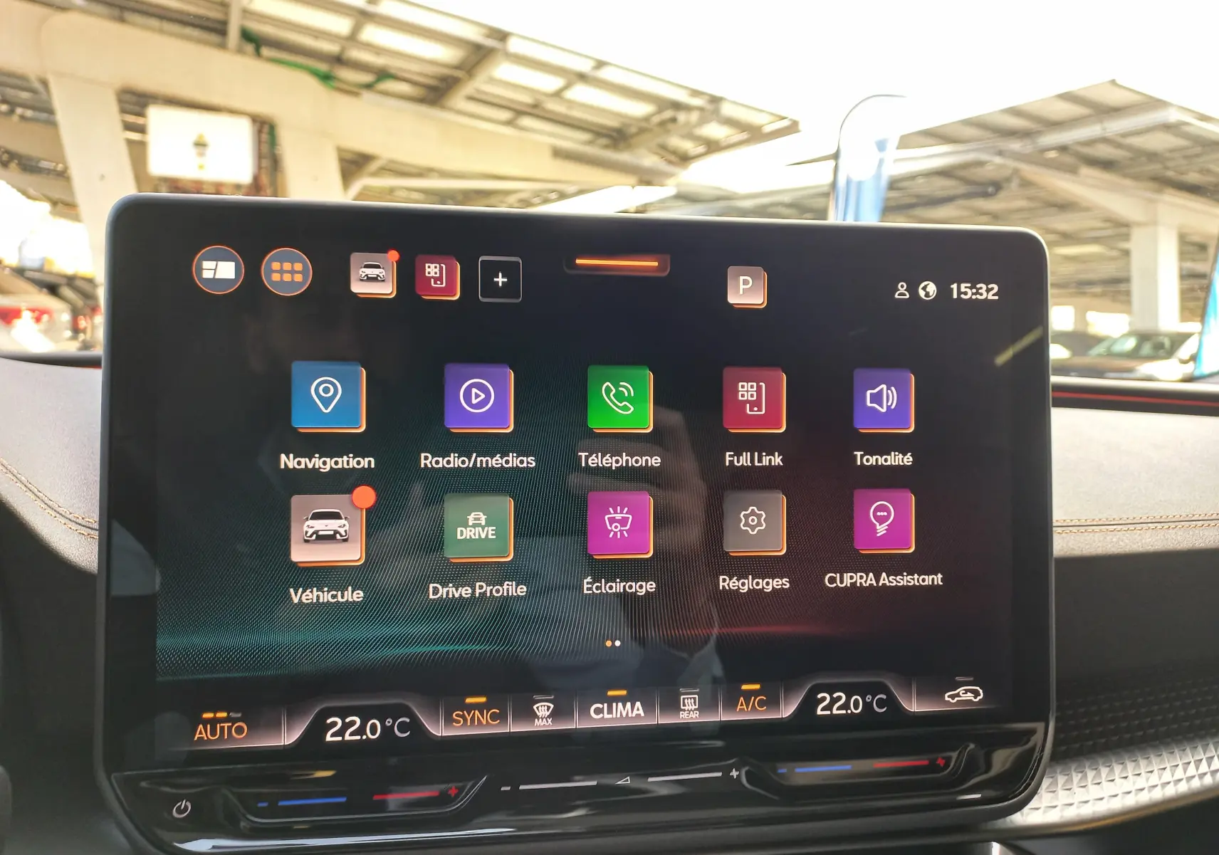 Écran tactile central du CUPRA Leon Ph.2 noir, affichant les menus de navigation et assistance à 15h32 dans un intérieur lumineux.