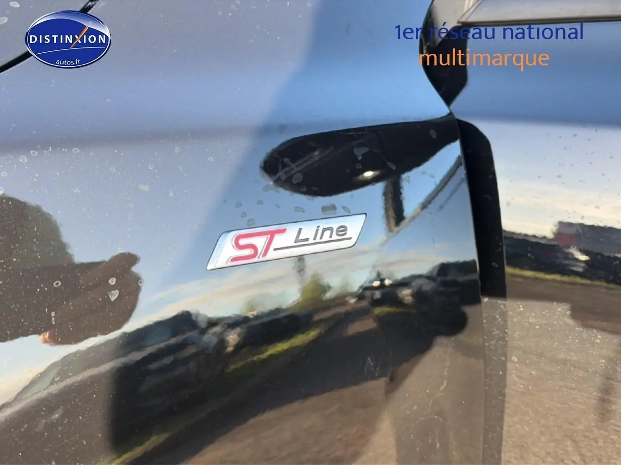 Gros plan sur l'emblème ST-Line sur la porte noire brillante d'une Ford Focus 2024.