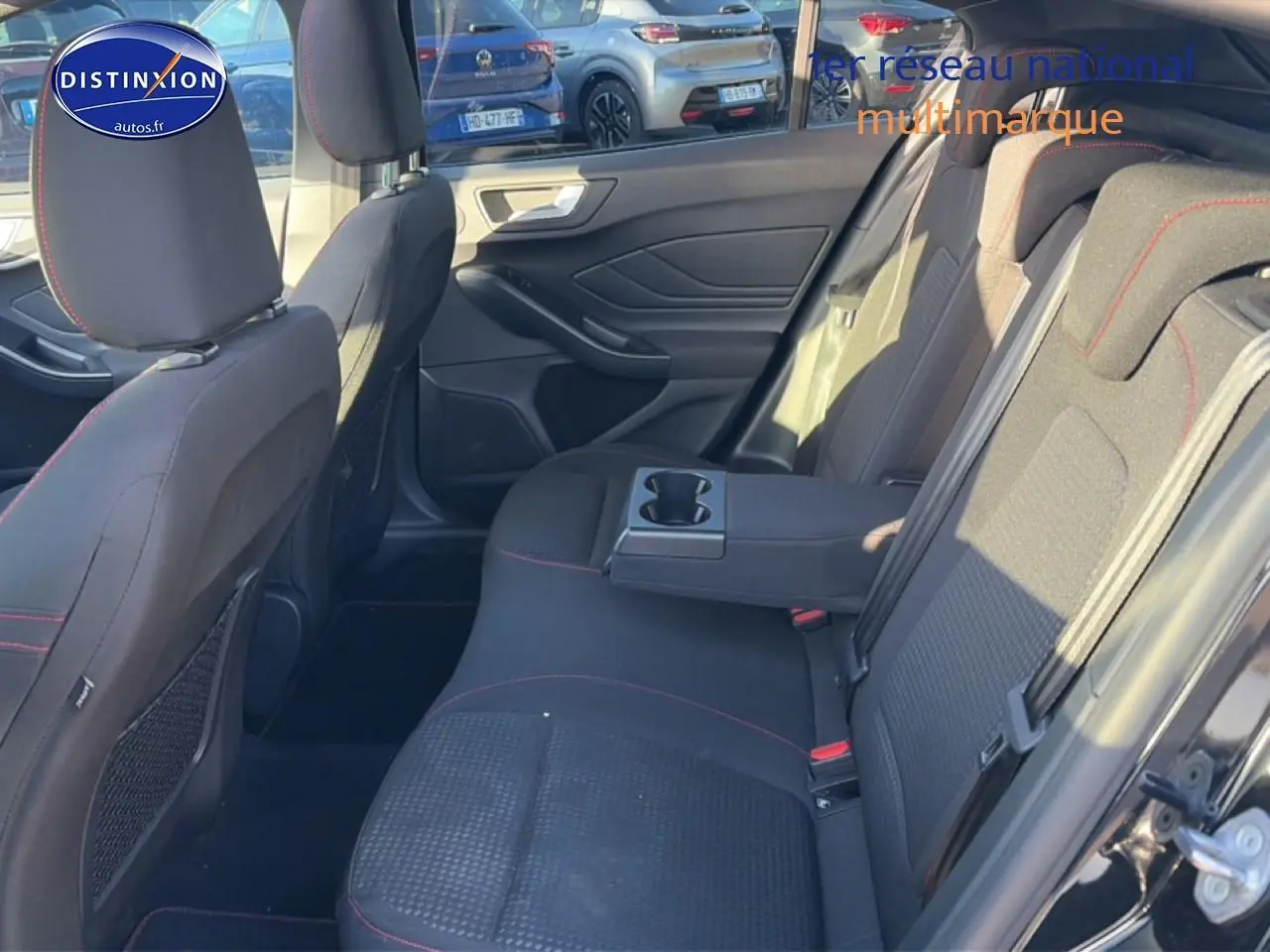 Vue intérieure côté droit des sièges arrière noirs avec accoudoir central et porte-gobelets de la Ford Focus 2024.