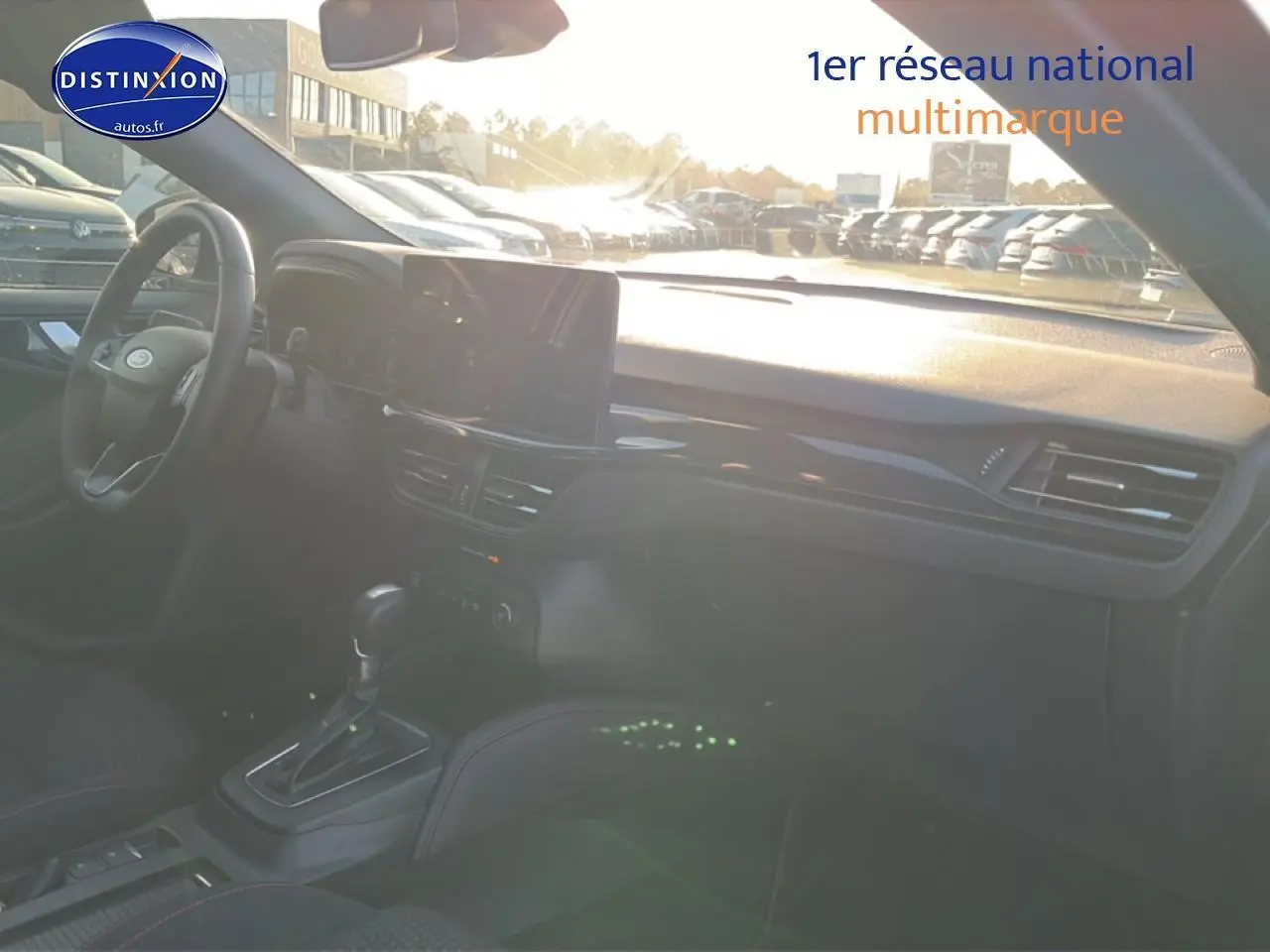 Vue intérieure avant droite de la Ford Focus noire 2024 avec tableau de bord moderne et écran tactile central.