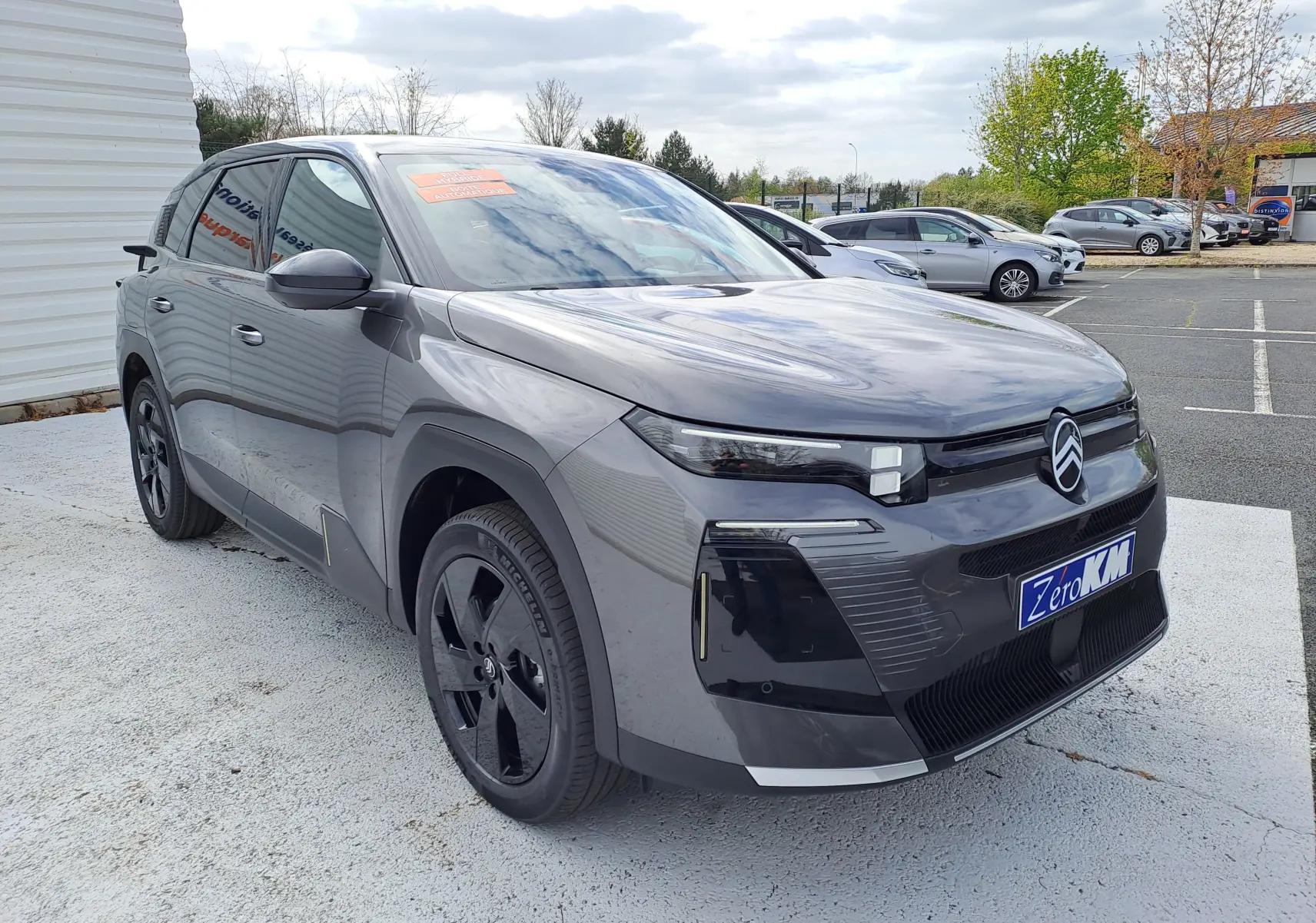 Vue de profil côté gauche d'un Citroën C5 Aircross gris platinium avec toit noir et jantes noires brillantes.