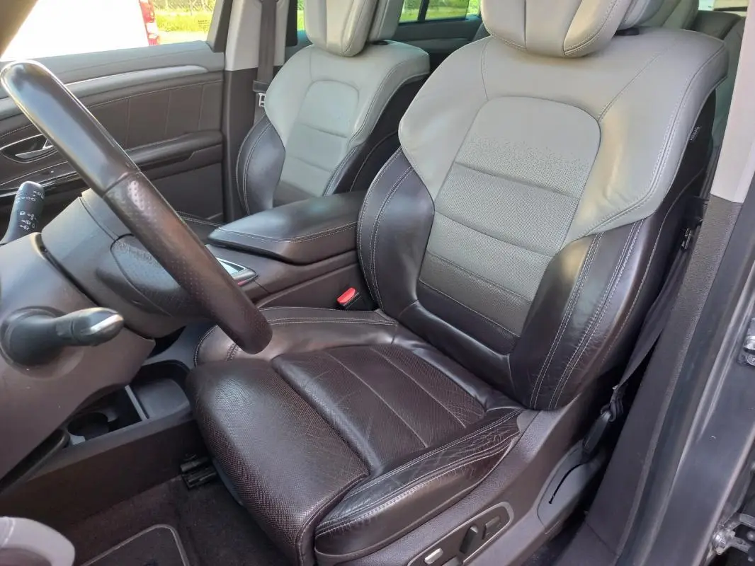 Vue intérieure côté conducteur du Renault Espace gris 2017, siège en cuir bicolore noir et gris avec commandes électriques.