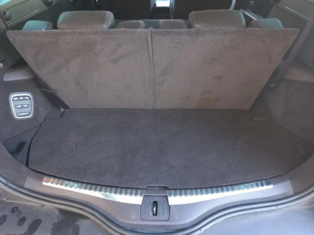 Coffre ouvert vu de l'arrière d'un Renault Espace gris 2017, montrant la banquette arrière et les commandes de rabattement.