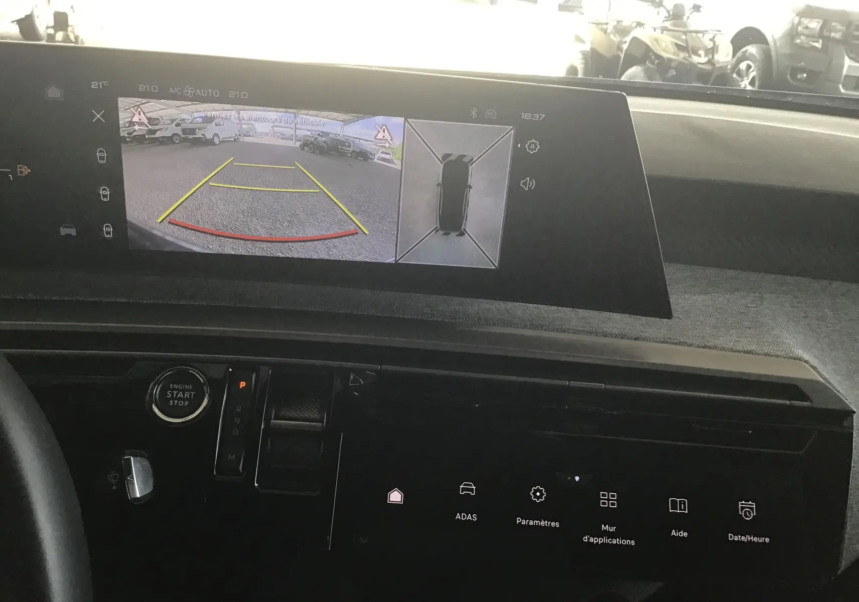 Vue intérieure du tableau de bord du Peugeot 3008 gris titane 2026, avec affichage caméra 360° et aide au stationnement.