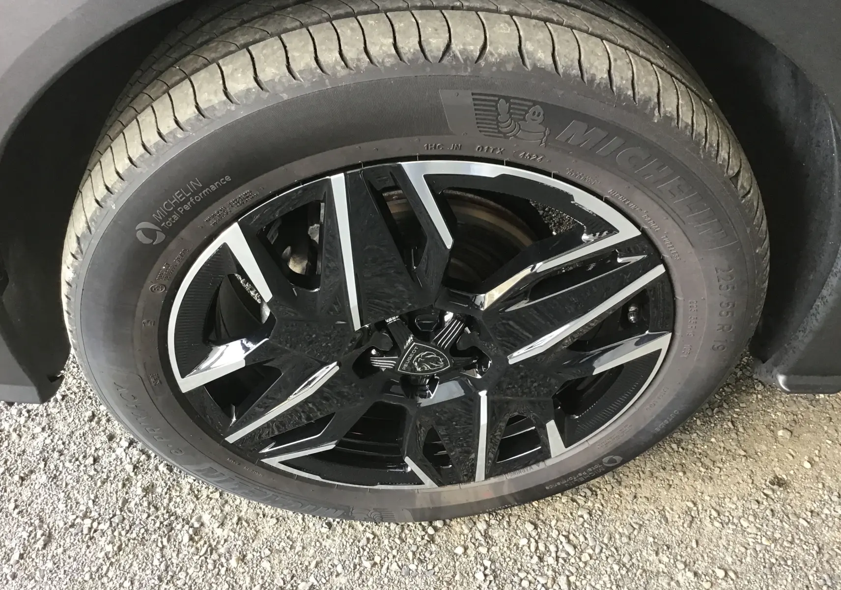 Gros plan sur la jante noire et argentée de 19 pouces d'un Peugeot 3008 gris titane, avec pneu Michelin visible.