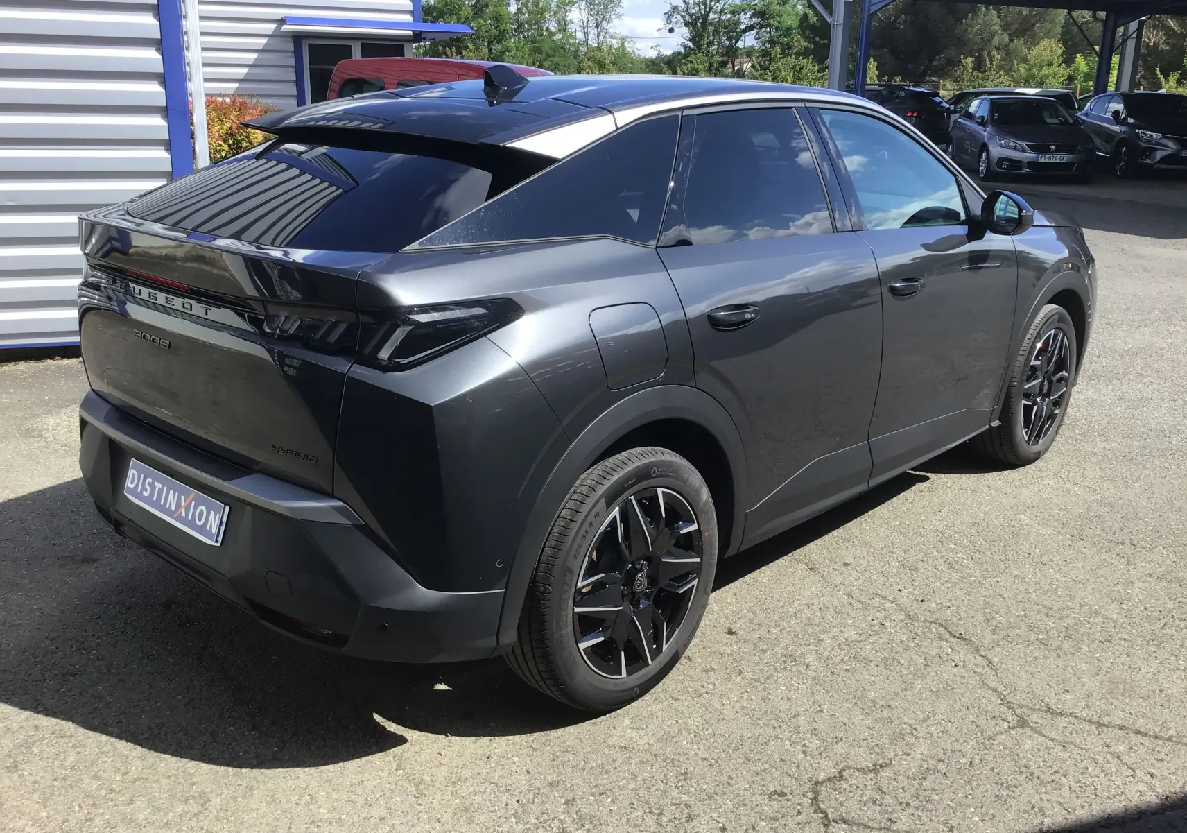 Peugeot 3008 1.2 Hybrid gris titane en 3/4 arrière droit, avec jantes noires et toit noir brillant.