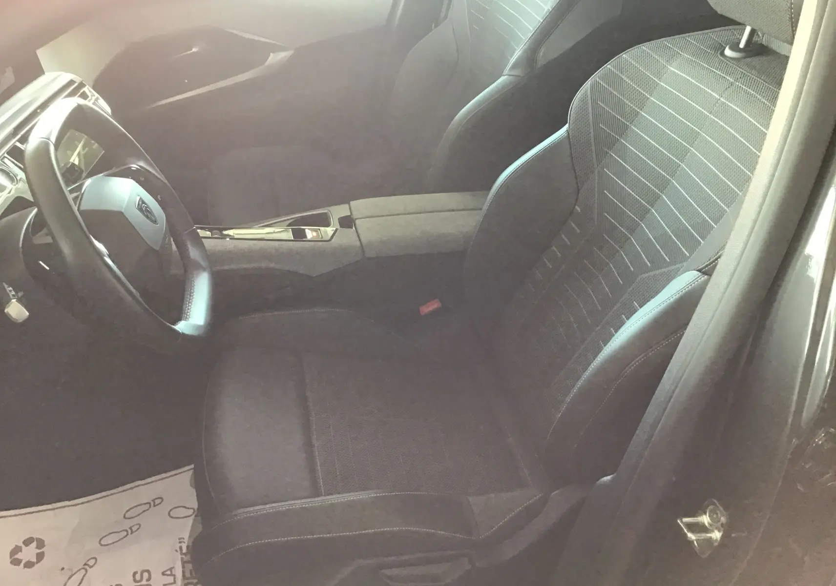 Vue intérieure côté conducteur du Peugeot 3008 gris titane, mettant en valeur le siège avant et le volant cuir.