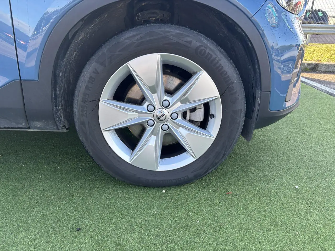 Gros plan sur la roue avant gauche avec jante alliage 18 pouces du Volvo XC40 Fjord Blue Metal.