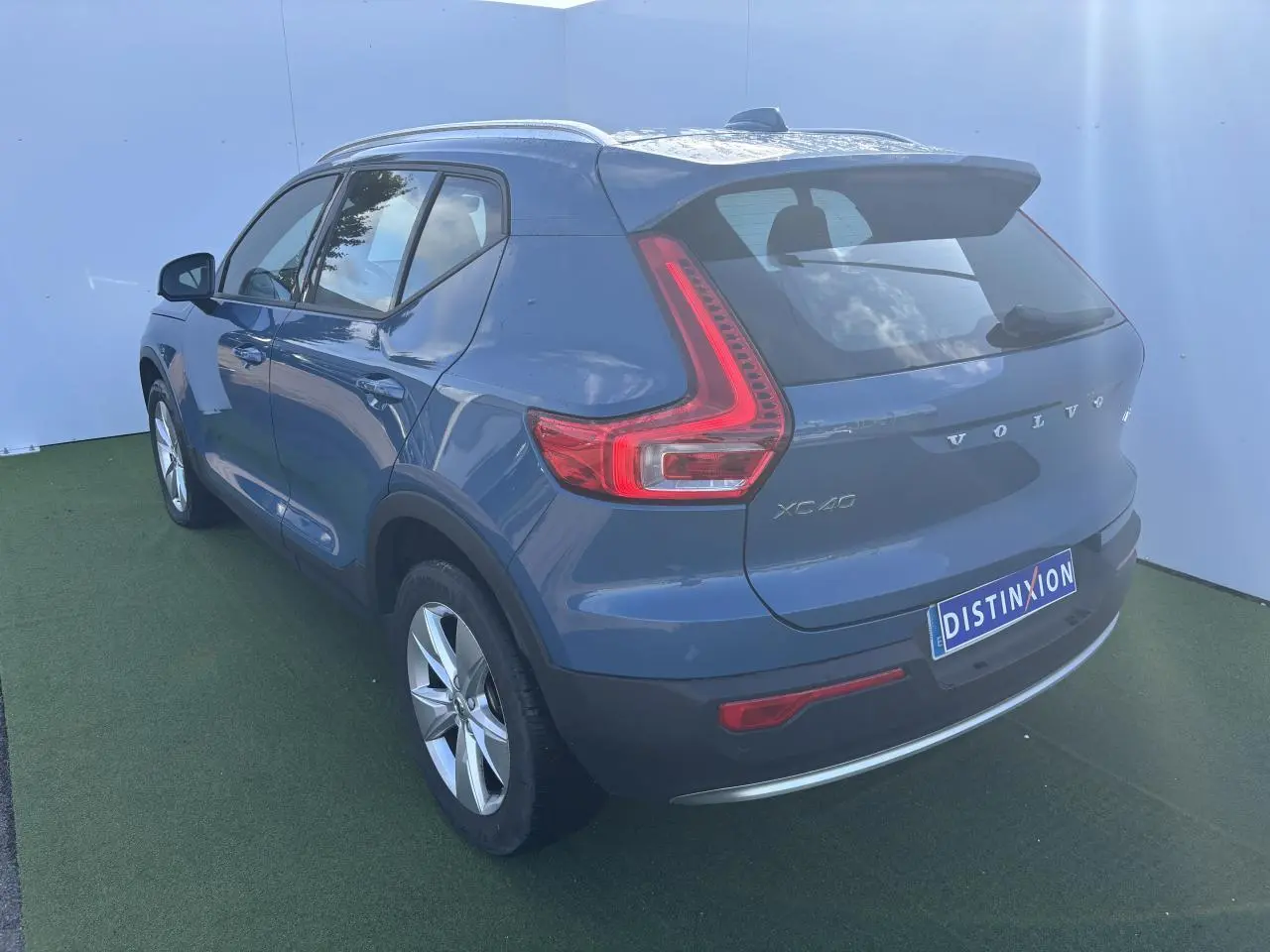 Vue 3/4 arrière droite d'un Volvo XC40 2024 Fjord Blue Metal avec feux arrière LED distinctifs et jantes alliage 18 pouces.