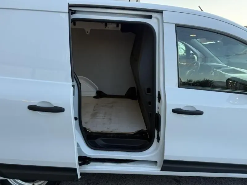 Vue latérale droite d’un Renault Kangoo blanc 2022 avec porte coulissante ouverte montrant l’espace de chargement vide.