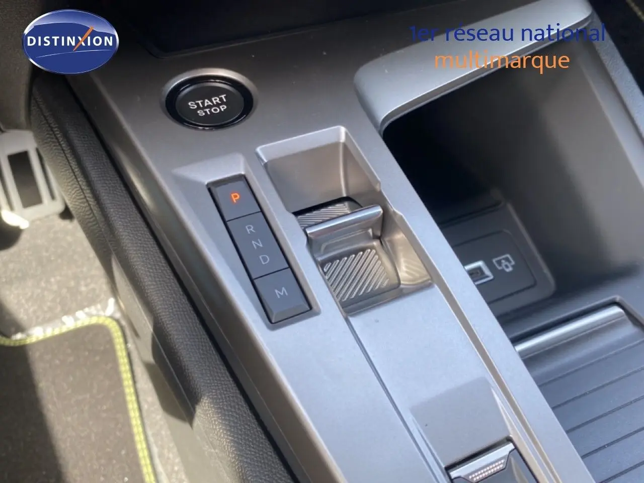 Gros plan sur la console centrale de la Peugeot 308 Hybrid 145ch GT, montrant la commande de boîte auto et le bouton start/stop.