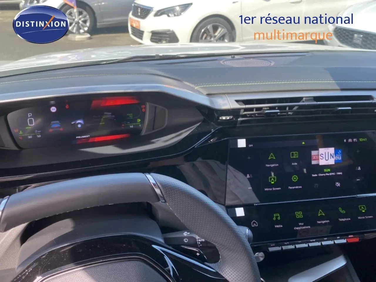 Vue intérieure du tableau de bord et volant noir de la Peugeot 308 Hybrid 145ch GT avec écran tactile central allumé.