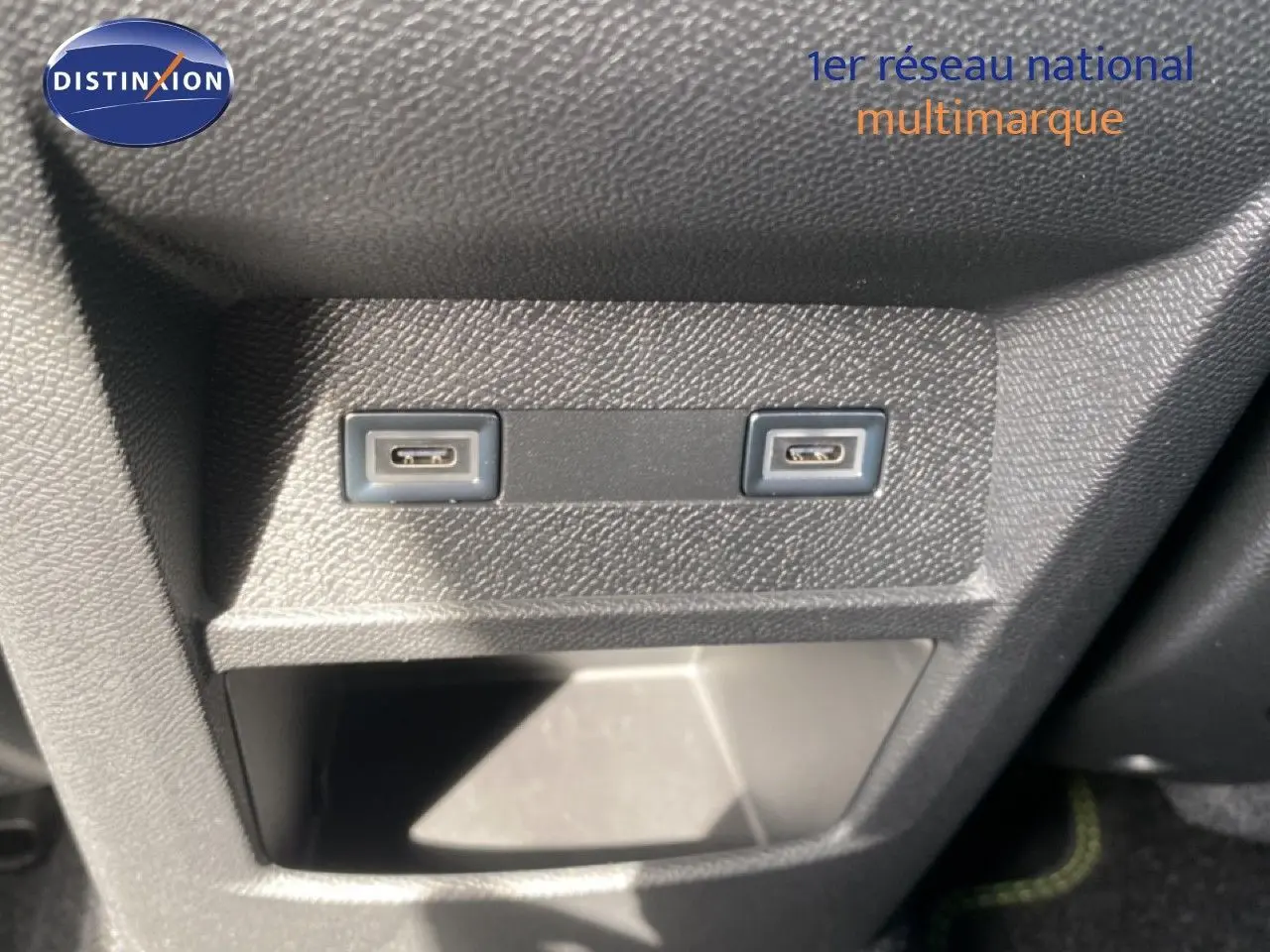 Gros plan sur deux ports USB-C intégrés dans la console centrale d'une Peugeot 308 Hybrid blanche.
